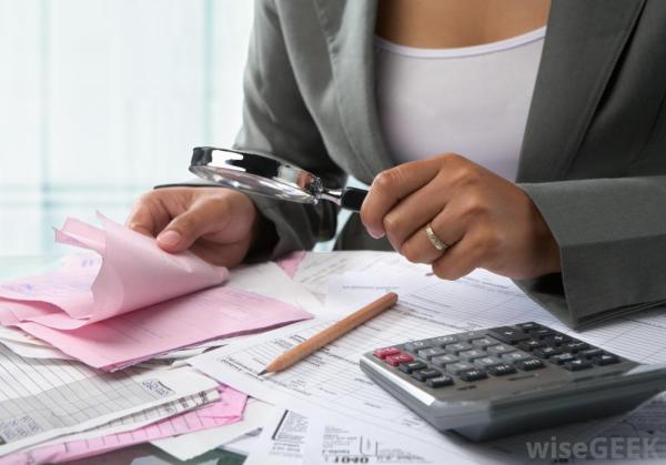 woman-in-suit-with-magnifying-glass-near-calculator